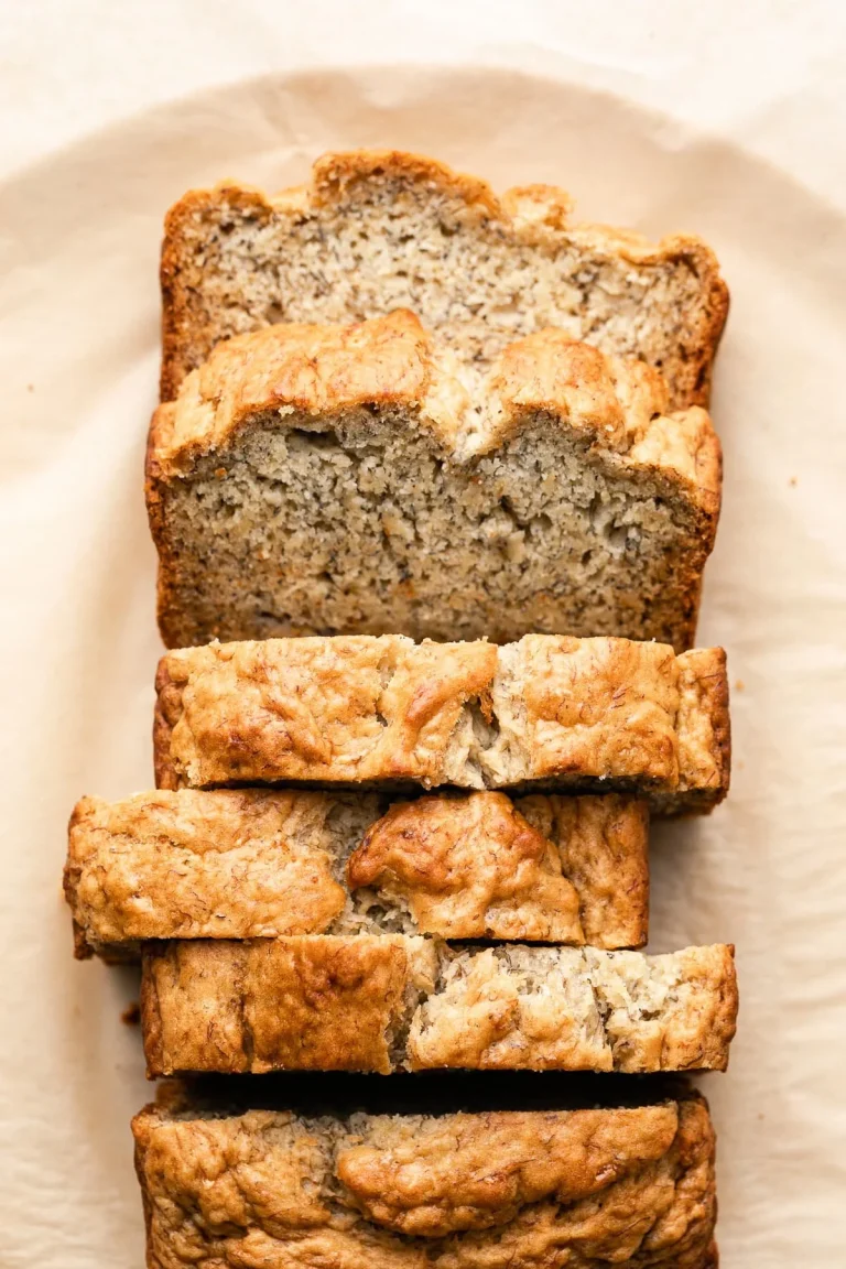 Delicious Vegan Banana Bread fresh out of the oven, topped with walnuts and bananas.